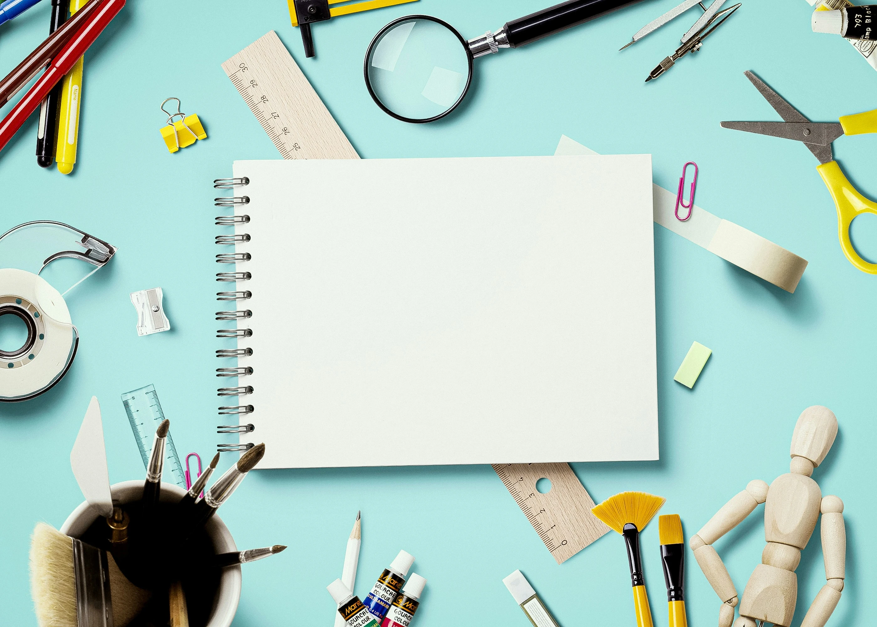 Material de papelería dispuesto sobre una mesa azul
